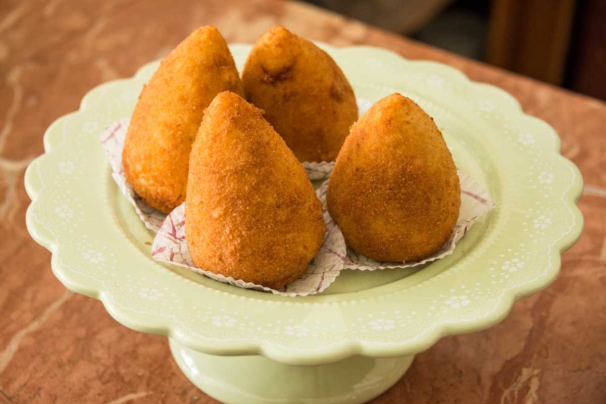 Piatto di arancine siciliane servite su un piatto di ceramica