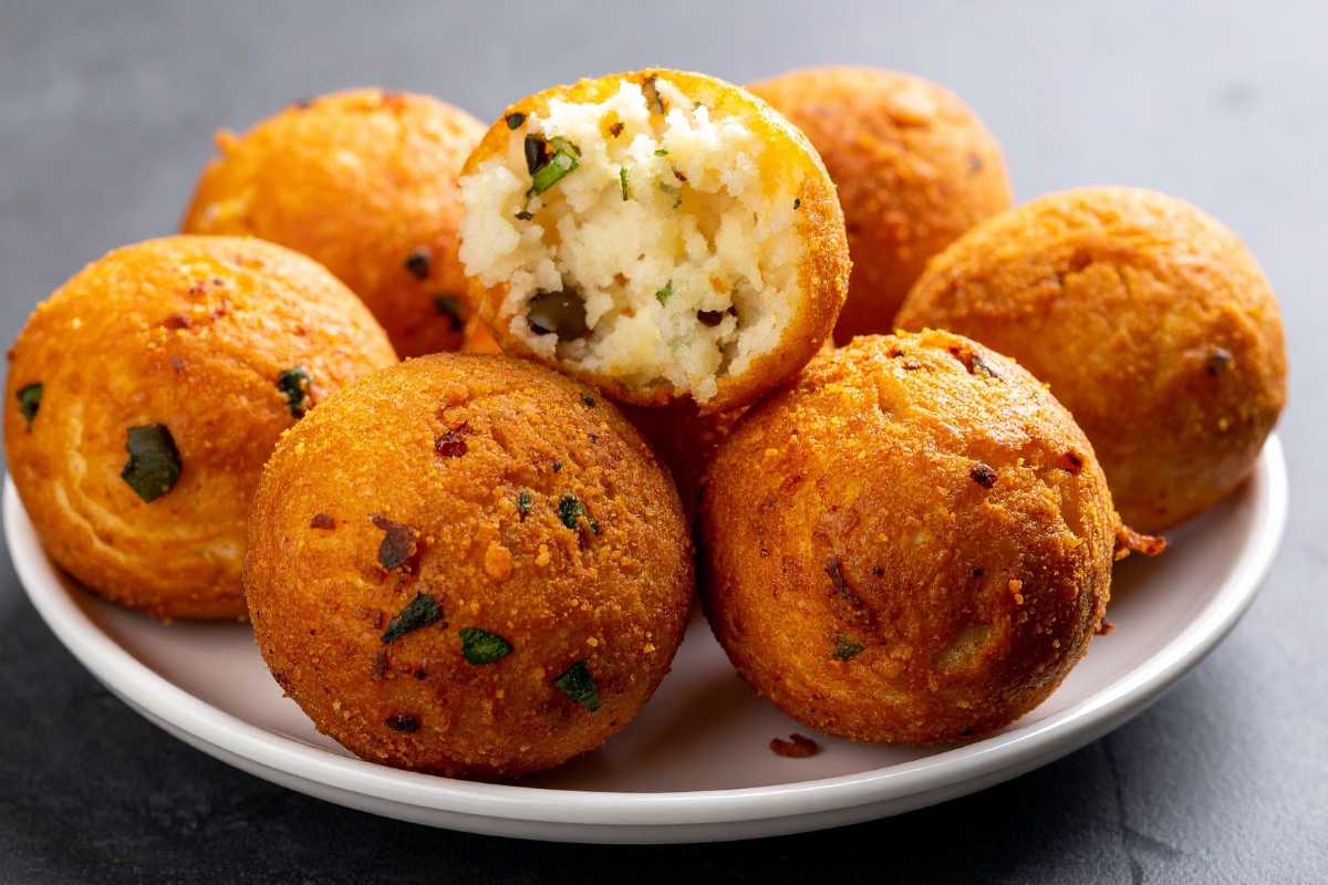 Arancini siciliani appena fritti su piatto di ceramica